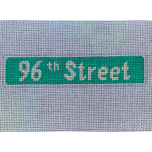 A needlepoint canvas with the text '96th Street' in green, indicating the kit's purpose for learning needlepointing techniques.